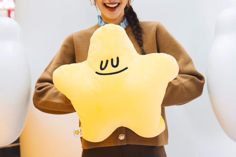 A person holding a yellow star pillow AI-generated content may be incorrect.
