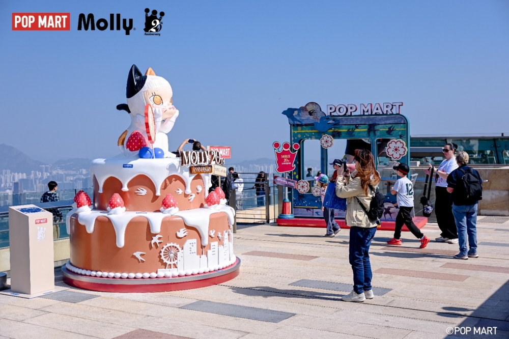 A group of people walking around a large cake

AI-generated content may be incorrect.