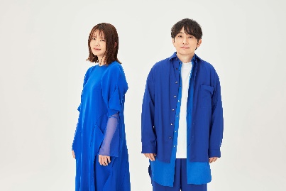 ネクタイをして立っている男性 中程度の精度で自動的に生成された説明