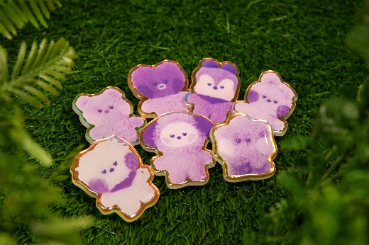 A group of purple and white teddy bears on grass

Description automatically generated