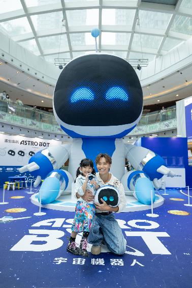 A person and a child posing in front of a giant robot

Description automatically generated