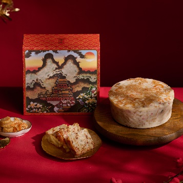 A round cake on a plate next to a box
Description automatically generated