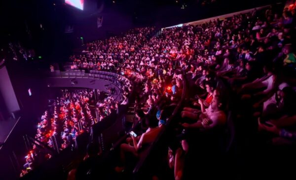 A large crowd of people in a concert hall AI-generated content may be incorrect.