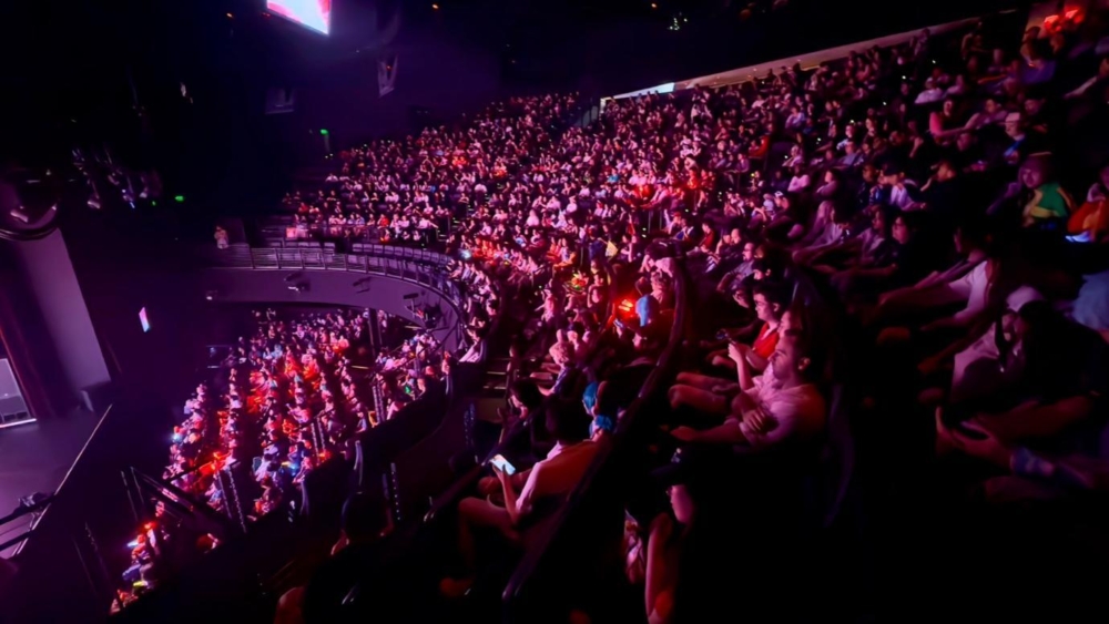 A large crowd of people in a concert hall
AI-generated content may be incorrect.